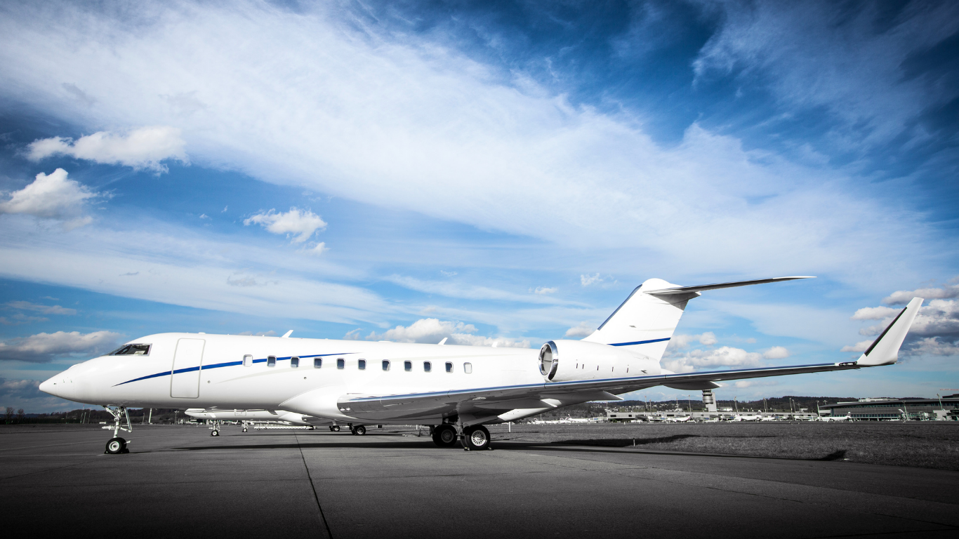 Private jet nose and fuselage on a sunlit apron — ultra-long-range aircraft ready for international departure