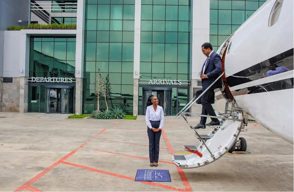 Passenger getting out of Pilatus PC-24 business jet on tarmac at Kinshasa airport, DRC mining sector