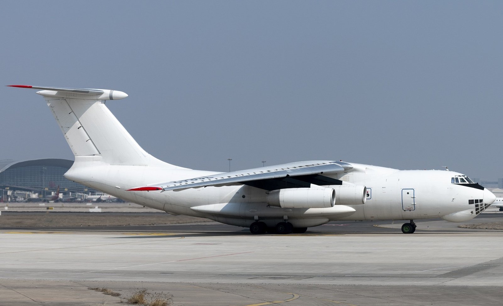 Ilyushin IL-76TD freighter on the tarmac with wing-mounted engines and swept tail visible, at an international airport