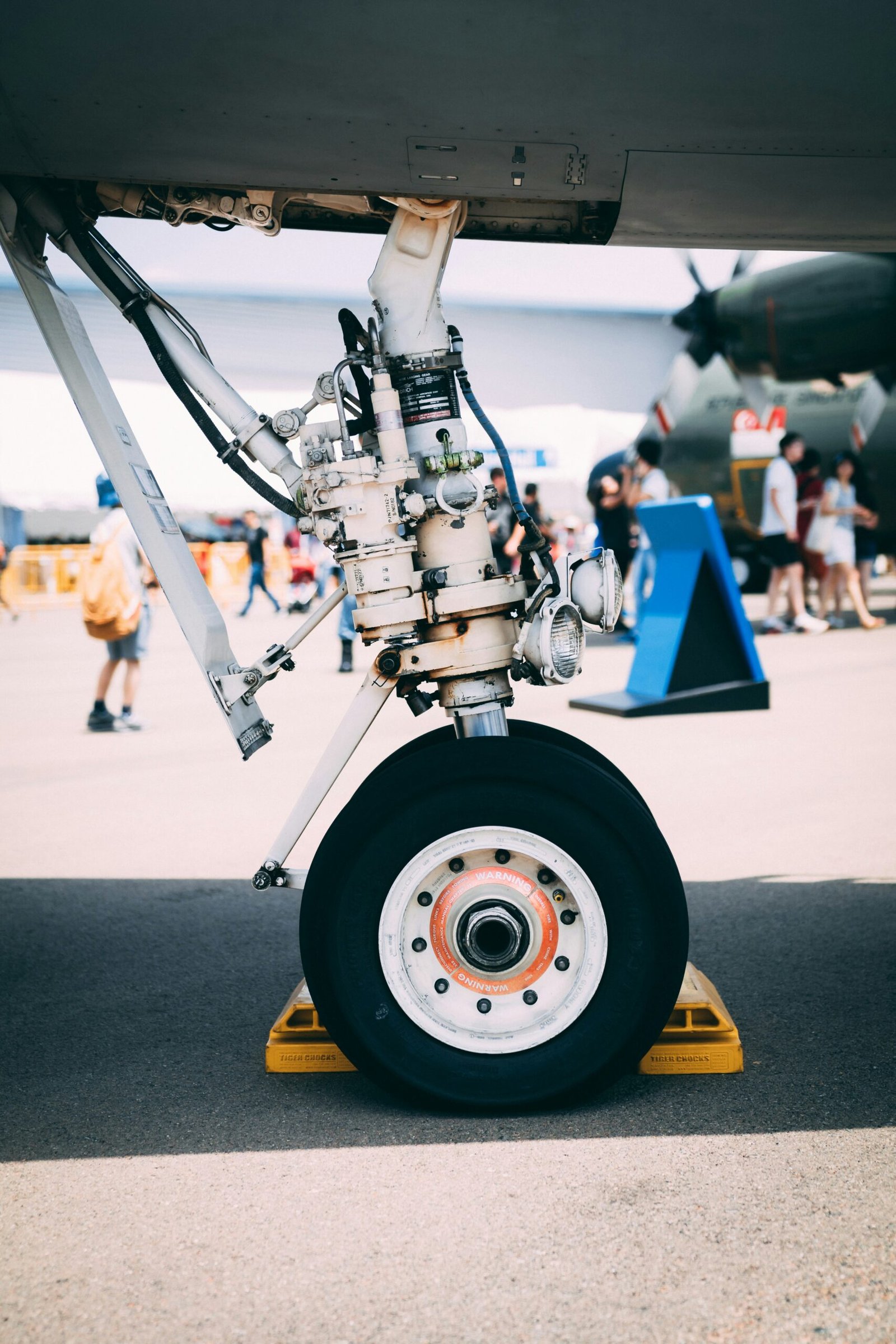 Aircraft landing gear on tarmac with ground crew