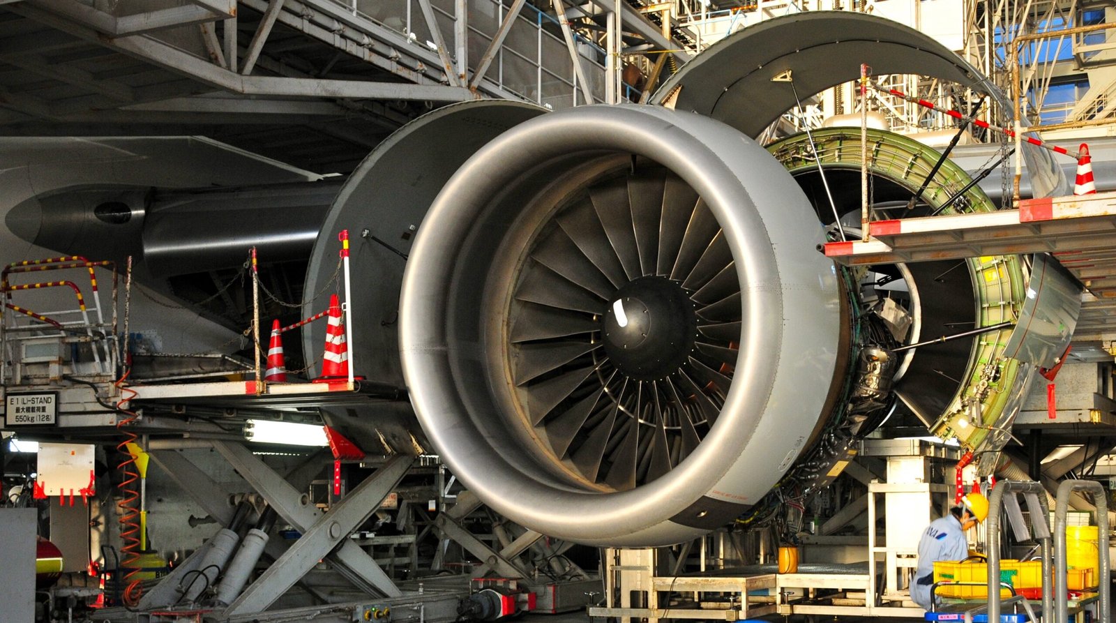 Complete external view of high-bypass turbofan jet engine mounted under aircraft wing showing nacelle, inlet cowl, fan cowl doors, thrust reverser panels with cascades, exhaust nozzle with chevrons, and mounting pylon
